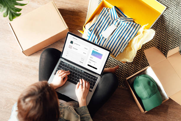 young woman doing online shopping with laptop sitting on the floor at home - fashion stock pictures, royalty-free photos & images