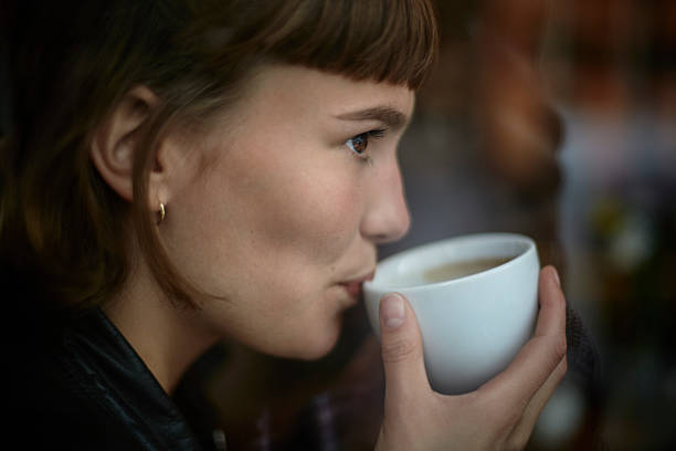 young woman drinking cup of coffee - coffee stock pictures, royalty-free photos & images
