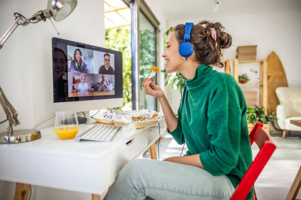 young woman having a video call with her friends - junk food stock pictures, royalty-free photos & images