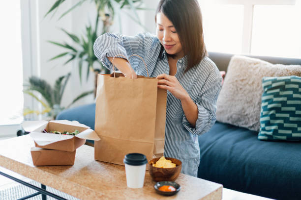 young woman having takeaway meal at home - food stock pictures, royalty-free photos & images