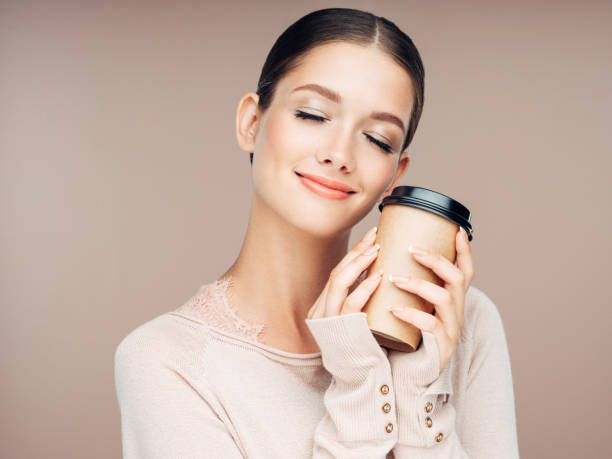 young woman holding hot coffee - junk food stock pictures, royalty-free photos & images