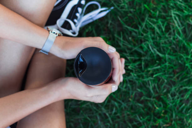 young woman holding reusable coffee cup. - junk food stock pictures, royalty-free photos & images