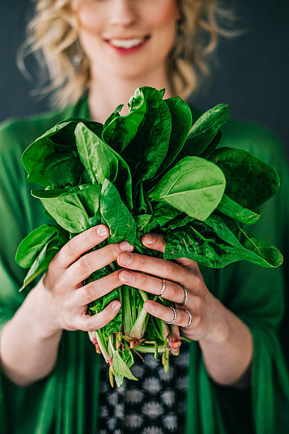 young woman holding spinach leafs salad - food stock pictures, royalty-free photos & images