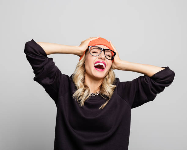 young woman laughing with hands in head - fashion stock pictures, royalty-free photos & images