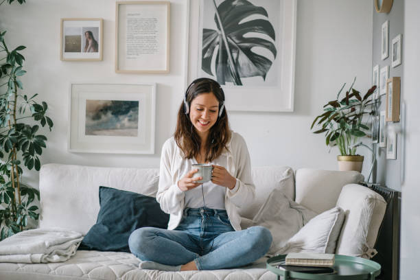 young woman listens to musics through headphones - home decoration stock pictures, royalty-free photos & images