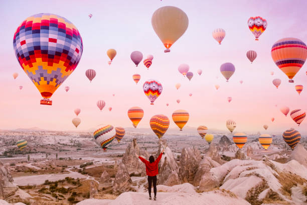 young woman on a background of flying balloons at sunrise in cappadocia - travel stock pictures, royalty-free photos & images