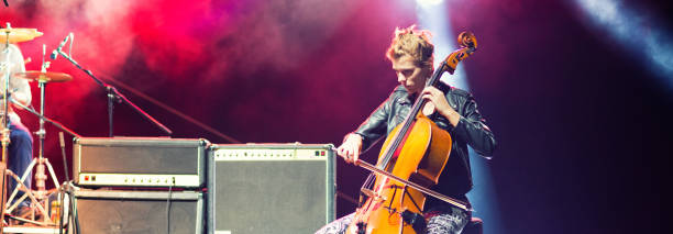 young woman playing cello on the concert stage - concert stock pictures, royalty-free photos & images