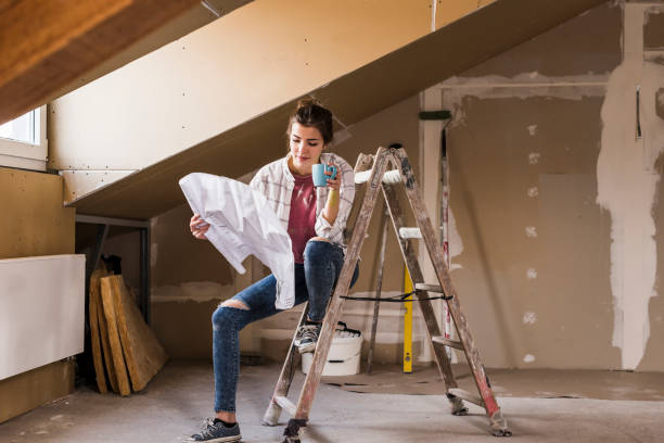 young woman renovating her new home, holding construction plan - home decoration stock pictures, royalty-free photos & images
