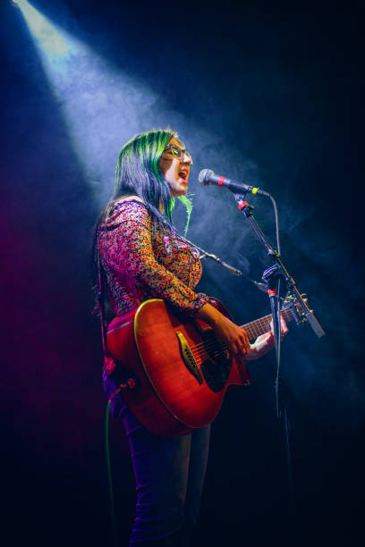 young woman singer under the spotlight - concert stock pictures, royalty-free photos & images