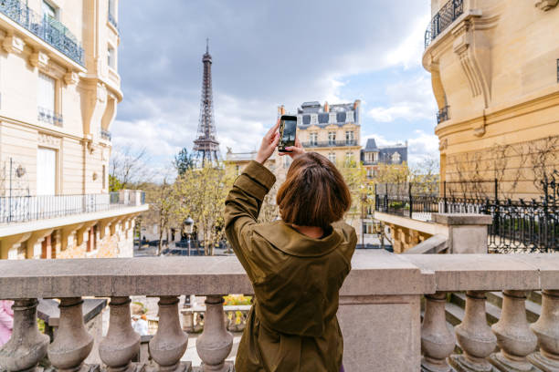 young woman taking pictures of an eiffel tower in paris in france - travel stock pictures, royalty-free photos & images