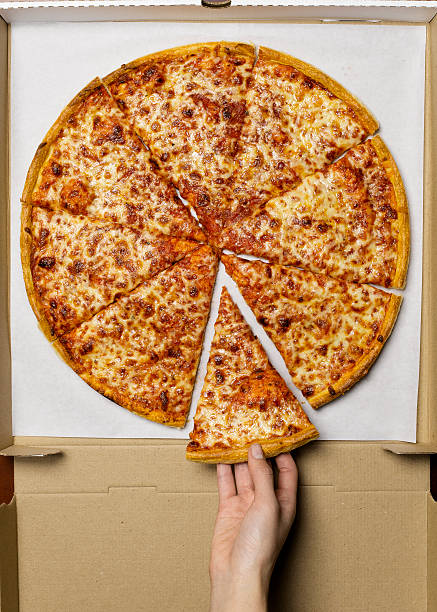 young woman taking slice of pizza, overhead view - junk food stock pictures, royalty-free photos & images