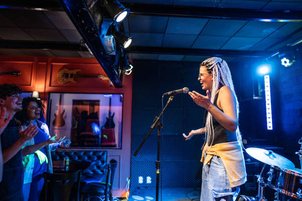 young woman talking during stand-up comedy show - concert stock pictures, royalty-free photos & images