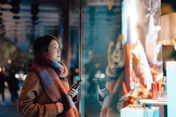 young woman window shopping in the city at night - fashion stock pictures, royalty-free photos & images