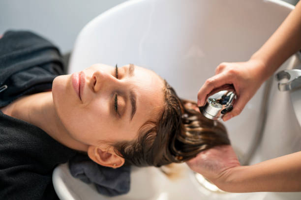 young women customer washing her hair by beautician after dye hair at beauty salon. beauty salon business. - hairstyle stock pictures, royalty-free photos & images