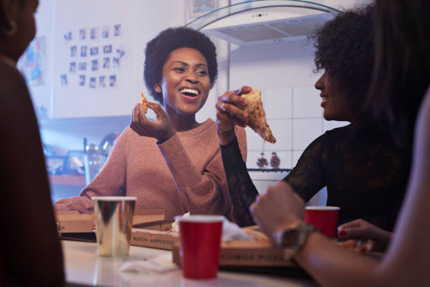 young women having party in the kitchen and eating pizza - junk food stock pictures, royalty-free photos & images