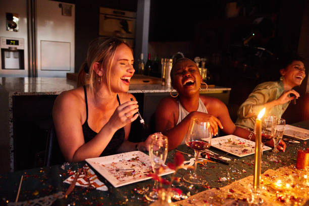 young women laughing together during a new year's eve dinner party - food stock pictures, royalty-free photos & images