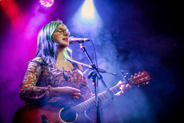 your woman singer and guitarist performing live concert - concert stock pictures, royalty-free photos & images