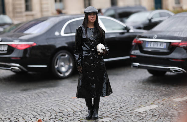 Yoyo Cao is seen outside Chanel show wearing black leather barrett, black patent Chanel coat, black leather high knee boots, white camellia Chanel...