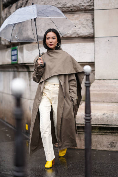 Yoyo Cao wears a gray trench long coat , beige pants , yellow pointed shoes , outside Hermes, during the Womenswear Fall/Winter 2024/2025 as part of...