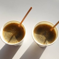 2 boxes of paper disposable cups without lid on the table in the cafe. coffee to go with the sticks . morning. coffee for breakfast. 2 cups of coffee. the shadows of the cups. - junk food stock pictures, royalty-free photos &