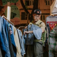 2nd hand jeans market, asian tourist man is interesting in a jacket. - fashion stock pictures, royalty-free photos & images