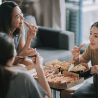 3 asian chinese female friends having pizza for lunch in their living room bonding time - junk food stock pictures, royalty-free photos & images