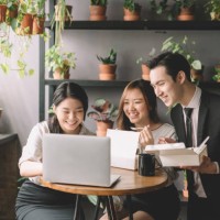 3 asian chinese office executive having lunch break at their cafeteria in office during noon with their lunch box and looking at laptop - junk food stock pictures, royalty-free photos & images