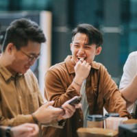 4 asian chinese eating popcorn waiting for movie show time at bar counter lobby lounge beside ticketing counter in cinema movie theater - junk food stock pictures, royalty-free photos & images