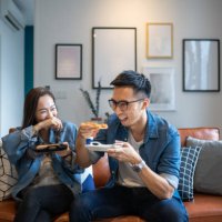 4 friends gathering at home for a quick meal - junk food stock pictures, royalty-free photos & images