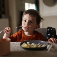 a 3 year old little boy having his lunch at home - food stock pictures, royalty-free photos & images
