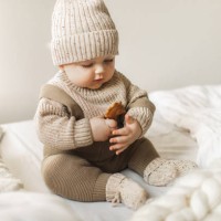 a 5 month old baby boy in cotton knitwear laying on a bed. - fashion stock pictures, royalty-free photos & images