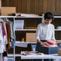a beautiful businesswoman packing a hat for shipping in her store - fashion stock pictures, royalty-free photos & images