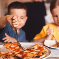 a boy and a girl share a pizza in a cafe. - junk food stock pictures, royalty-free photos & images