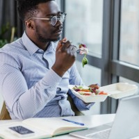 a businessman is having a lunch break in the office - junk food stock pictures, royalty-free photos & images