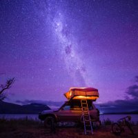 a camper van at nightfall near water body. - travel stockfoto's en -beelden