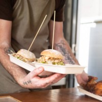 a chef serves two chicken burgers and a roast chicken from a food food truck - junk food stock pictures, royalty-free photos & images