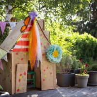 a child's colourful homemade playhouse in a back yard made from recycled cardboard boxes - garden decoration stock pictures, royalty-free photos & images