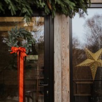 a christmas wreath and pine branches hanging on a house outside - home decoration stockfoto's en -beelden