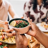a close up view of an unrecognizable woman giving food to a caucasian female - food stock pictures, royalty-free photos & images