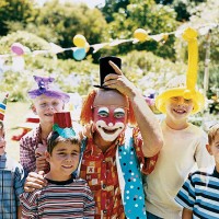a clown posing with boys at a birthday party in a garden - garden decoration stock pictures, royalty-free photos & images