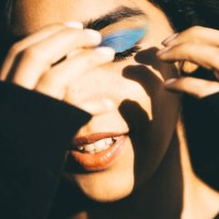 a conceptual fashionable portrait of a woman with bright blue eyeshadow against the sun - fashion stock pictures, royalty-free photos & images