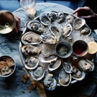 a couple enjoying raw oysters - food stockfoto's en -beelden