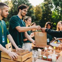 a couple is taking a bag of food at the food and clothes bank - food stock pictures, royalty-free photos & images