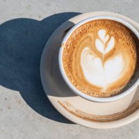 a cup of latte coffee on table. - coffee stock pictures, royalty-free photos & images