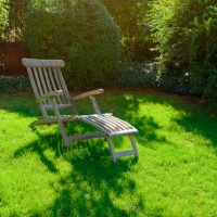 a deck chair stands in a garden on a green meadow in summer - garden decoration photos et images de collection