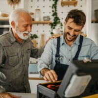 a dedicated male carpenter adeptly works on the installation and repair of kitchen components in a senior gentleman's residence, showcasing professionalism and expertise - home decoration stock pictures, royalty-free photos &