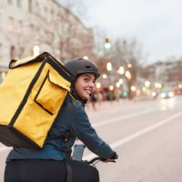 a delivery biker looking over their shoulder. - food stock pictures, royalty-free photos & images