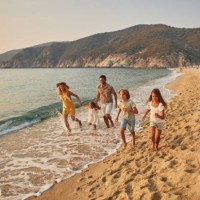 a family run hand in hand down a tropical paradise beach during sunset - travel stock pictures, royalty-free photos & images