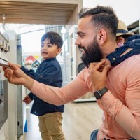 a father and two sons looking at ovens in an appliance store. - home decoration stock pictures, royalty-free photos & images