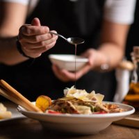 a female chef pouring sauce on salad - food stock pictures, royalty-free photos & images